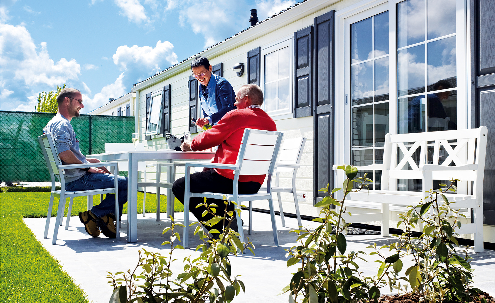 Afbeelding van een gezellig gezin bij een caravan